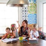 A-woman-sitting-on-a-table-with-her-3-kids