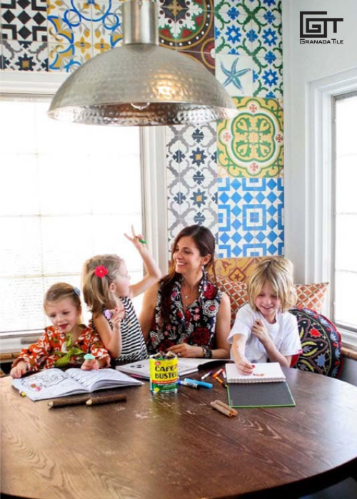 A woman sitting on a table with her 3 kids