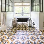 A bathroom with a bathtub, window, and Toscano pattern tiles