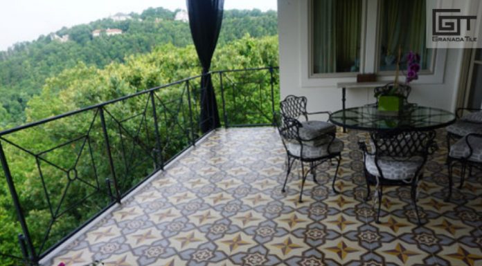 A covered balcony with encaustic tiled flooring, a table, and 3 chairs