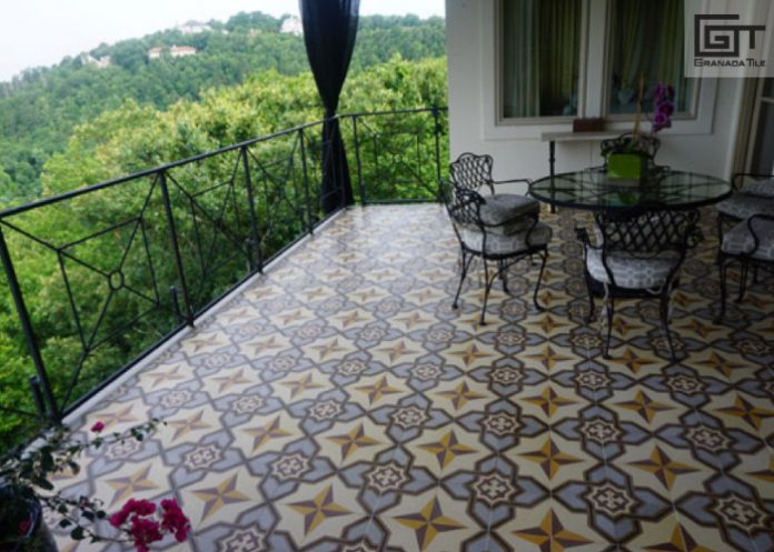 A covered balcony with encaustic tiled flooring, a table, and 3 chairs