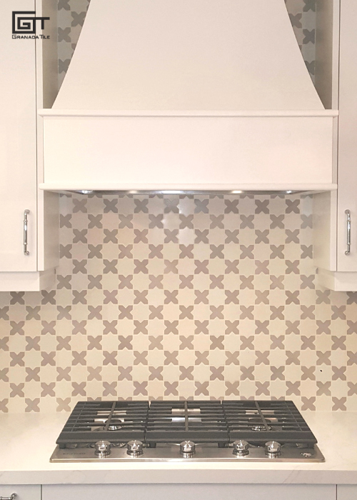 A white and gray kitchen with a stainless steel stove top