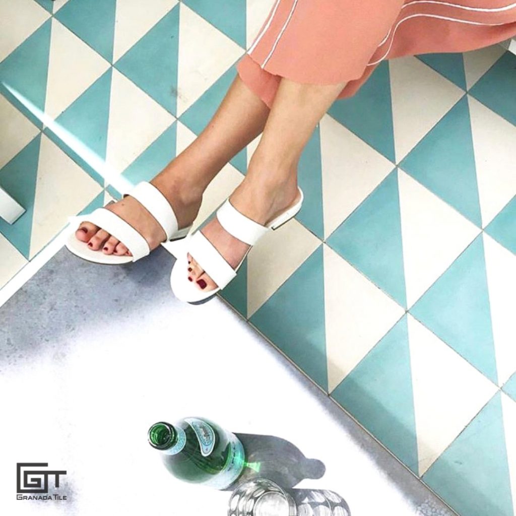 A woman sitting inside a patio covered with Granada Tile’s Luxor cement tiles