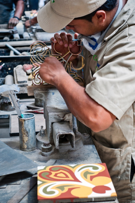 A man working on a homemade encaustic cement tile