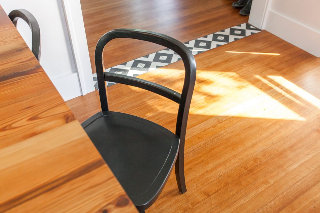 A table, two chairs, and a floor with a strip of Serengeti tiles