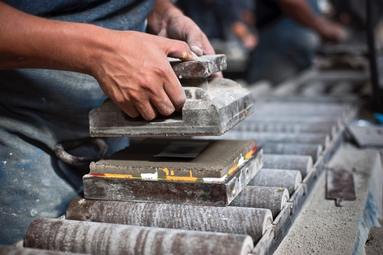 Someone in the process of making a homemade cement tile