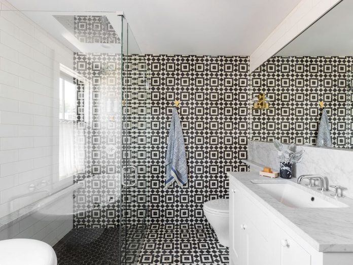 The floor and back wall of a bathroom covered with Granada Tile's Slate-and-white Fez 928 tile