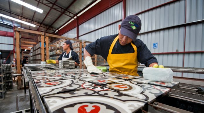 A worker creating cement tiles