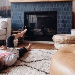 A kid lying in front of Fireplace