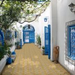 outdoory patio with yellow and beige titles with blue doors and staircase