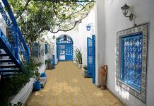 outdoory patio with yellow and beige titles with blue doors and staircase