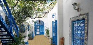 outdoory patio with yellow and beige titles with blue doors and staircase