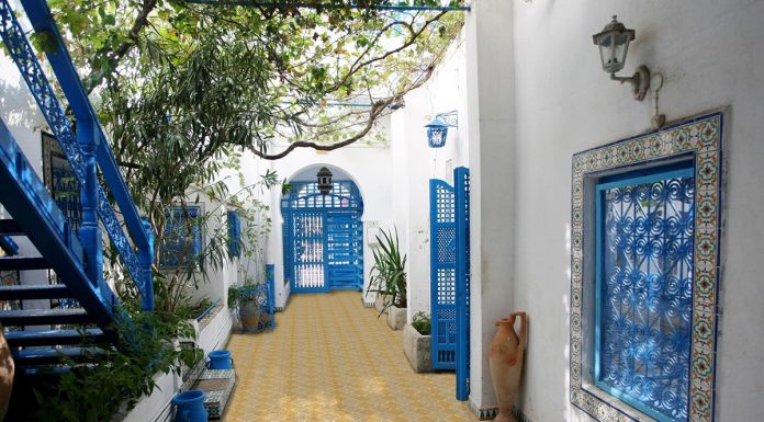 outdoory patio with yellow and beige titles with blue doors and staircase