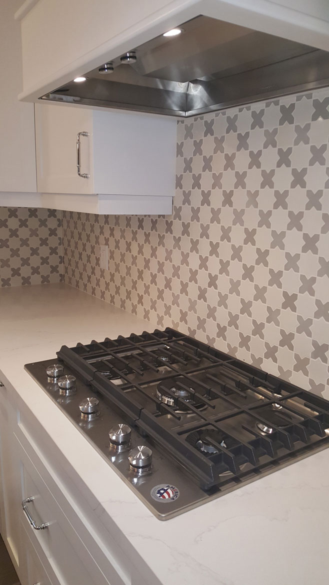 Close up of kitchen backsplash with small cement tiles in star and cross pattern